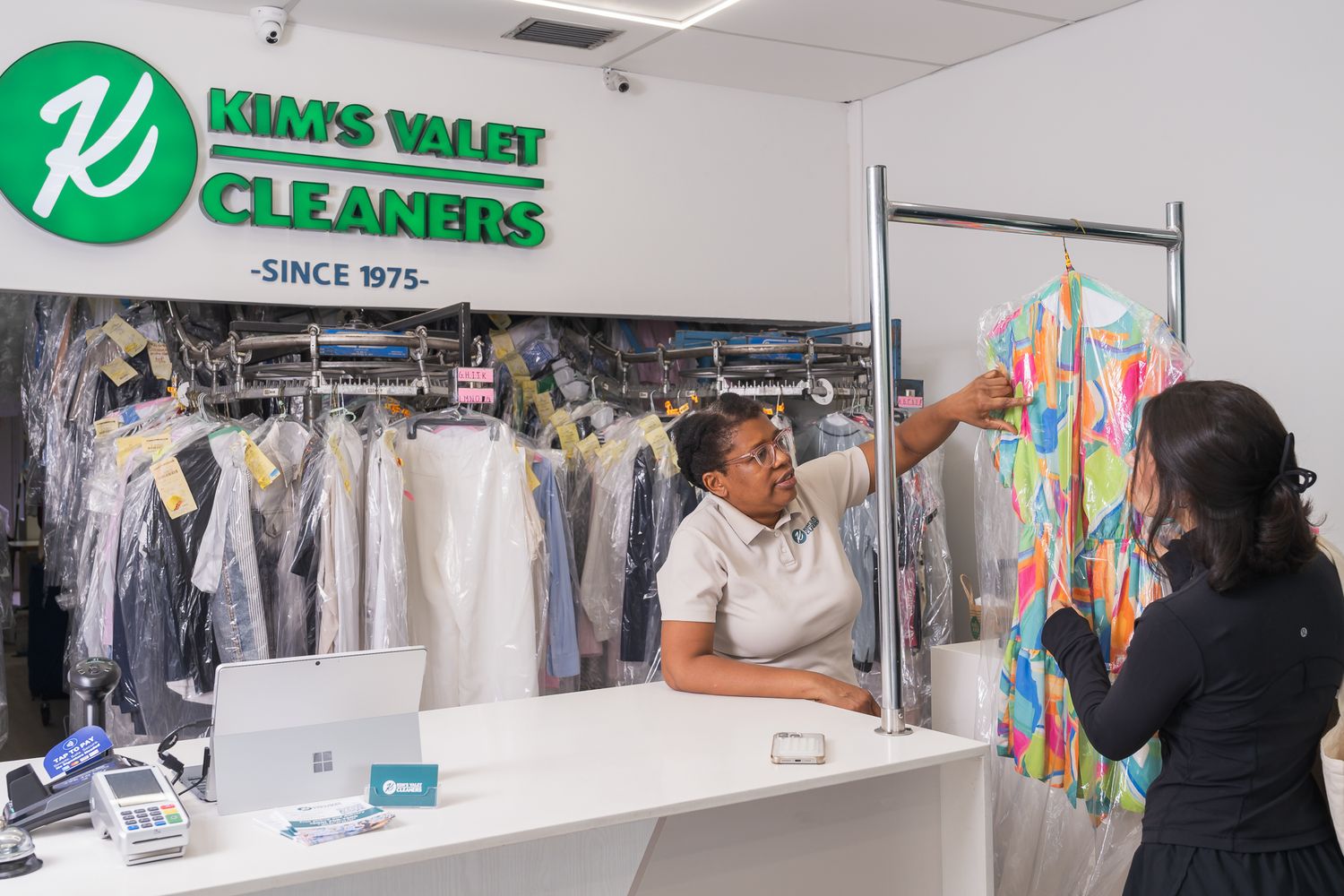 A freshly dry-cleaned garment handed back at the Kim's Valet Cleaners counter